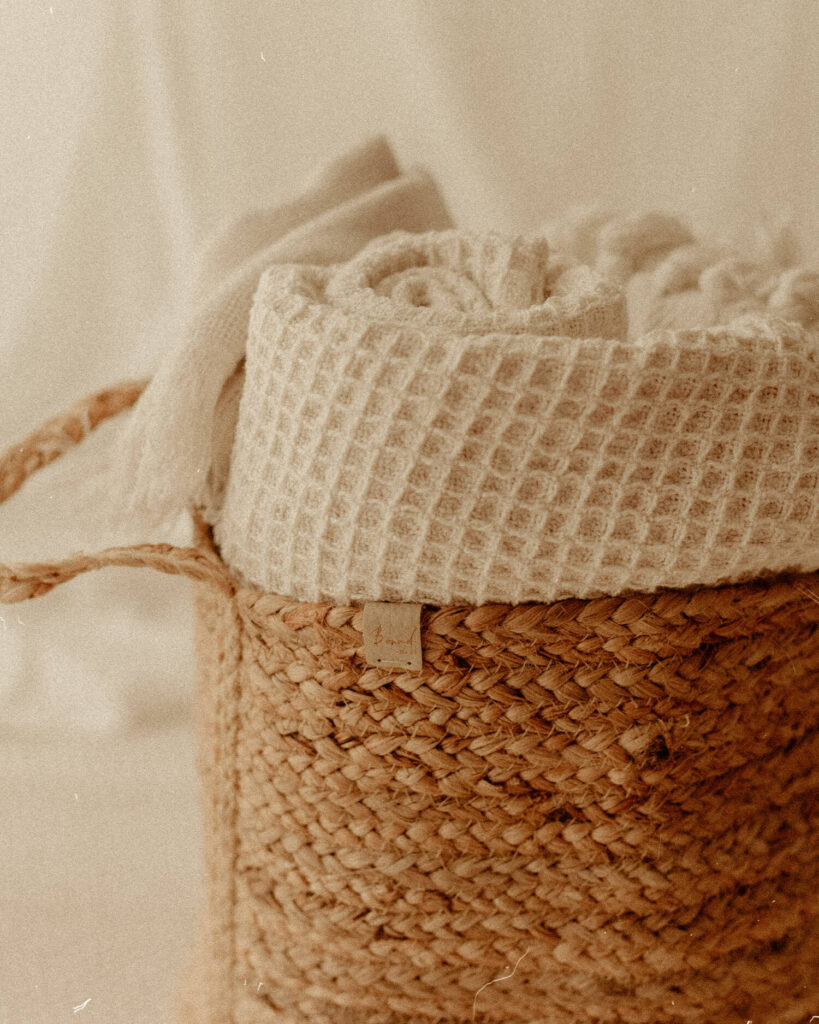 Cream blankets rolled up in woven baskets in my cotswold photography studio