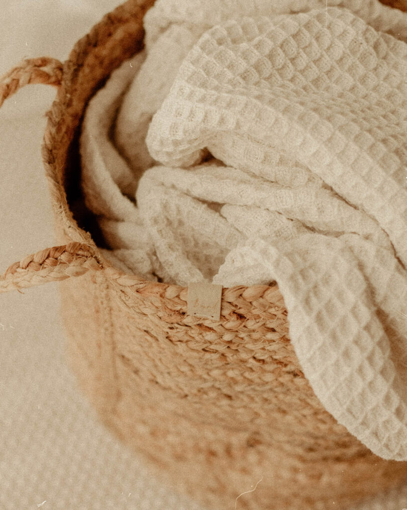 Cream blankets rolled up in woven baskets in my cotswold photography studio